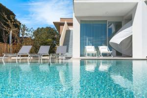 a group of chairs sitting next to a swimming pool at Bedda Matri in Noto