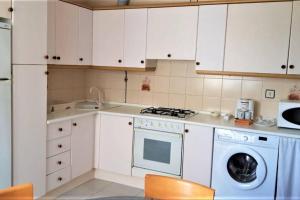 uma cozinha com armários brancos e uma máquina de lavar louça em Sella em Arriondas