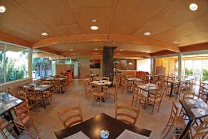 an empty restaurant with wooden tables and chairs at Hotel Smeraldo in Sirmione