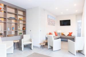 a living room with white chairs and a couch at Hotel Méditerranée in Collioure