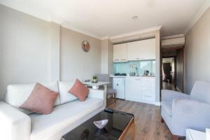 a living room with a white couch and a kitchen at 6 Apartment Galata in Istanbul