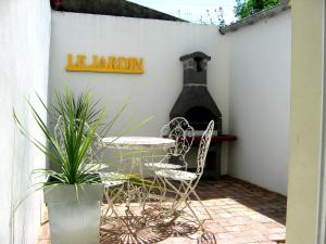 a patio with a table and chairs and a pizza oven at The Heart of Sainte Mere Eglise in Sainte-Mère-Église