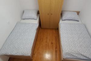 2 camas individuais num quarto com pisos em madeira em Cottage near river Kolpa, vineyards,top location. em Adlešiči
