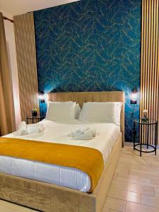 a bedroom with a large bed with a blue wall at B&B Bovio Square XIV in Naples