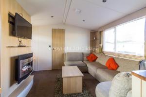 sala de estar con sofá y TV en 8 Berth, Dog Friendly Caravan At Haven Caister In Norfolk Ref 30031b en Great Yarmouth