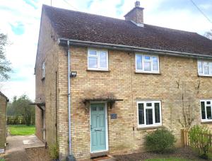 a brick house with a blue door at Jersey Cottage in Horseheath