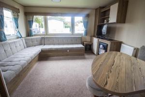 een woonkamer met een bank en een tafel bij Superb 8 Berth Caravan At Caister Beach In Norfolk Ref 30073f in Great Yarmouth