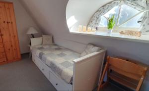 um pequeno quarto com uma cama e uma janela em FeWo Sonnenblume Achtern Diek em Zingst