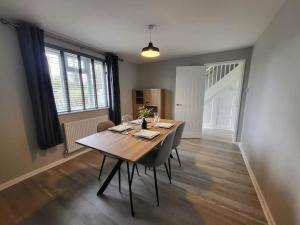 a dining room with a wooden table and chairs at Jersey Cottage in Horseheath