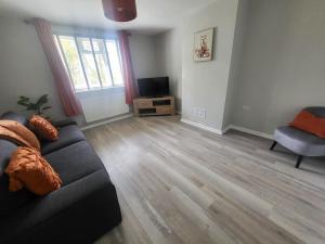 a living room with a couch and a television at Jersey Cottage in Horseheath