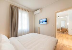 - une chambre avec un lit blanc et un miroir dans l'établissement #White Lotus by halu! Apartments, à Thessalonique