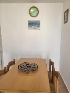 uma mesa de jantar com um relógio na parede em La casetta em San Vito Chietino