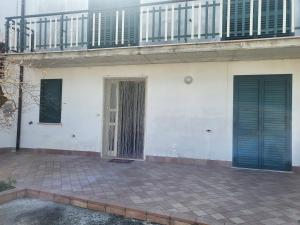 ein weißes Gebäude mit zwei Türen und einem Balkon in der Unterkunft La casetta in San Vito Chietino