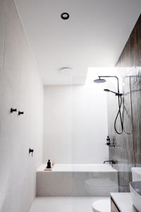 a white bathroom with a tub and a sink at Luxury Alpine Stay with Epic Views at Mt Buller foothills in Merrijig