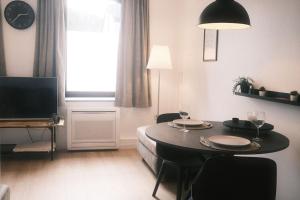 een woonkamer met een tafel en een televisie bij Le Rotche I in La-Roche-en-Ardenne