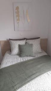 a bed with four pillows on top of it at Résidence calme, parking gratuit in Illzach