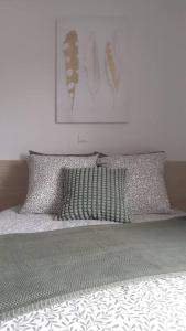 a bed with two pillows on top of it at Résidence calme, parking gratuit in Illzach