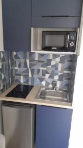 a kitchen with a sink and a microwave at Résidence calme, parking gratuit in Illzach