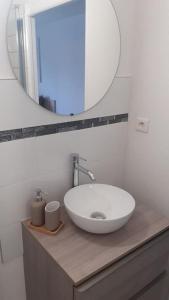 a bathroom with a white sink and a mirror at Résidence calme, parking gratuit in Illzach