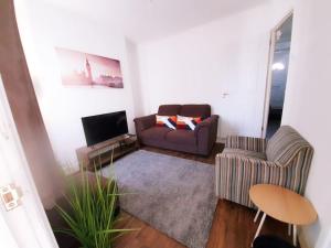 a living room with a couch and a chair at May Disc - Long Stay - Contractors in Swindon