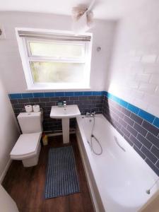 a bathroom with a toilet and a sink and a tub at May Disc - Long Stay - Contractors in Swindon