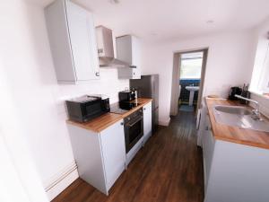 a kitchen with white cabinets and a sink at June Disc - Long Stay - Contractors in Swindon