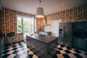 a kitchen with a refrigerator and a checkered floor at Chez Marraine in Nassogne
