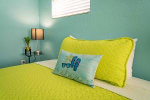 a bedroom with a yellow bed with a yellow pillow at Beds n' Drinks in Miami Beach