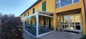 a yellow building with a patio with a table and chairs at Vele Storiche Pisane in Pisa