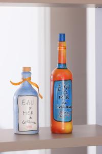 two bottles of alcohol sitting on a shelf at Hotel Méditerranée in Collioure