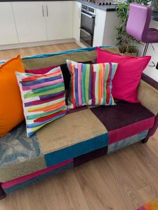 a couch with colorful pillows on it in a living room at ARDUTHIE STREET in Stonehaven