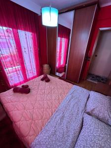 a bedroom with a large bed with pink curtains at Skytrack SA in Thessaloniki