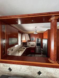 a large kitchen with wooden cabinets and a large mirror at Skytrack SA in Thessaloniki