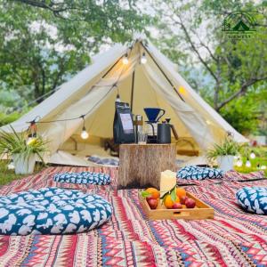 a tent with a table with a tray of fruit on it at Đào Hoa Glamping in Hanoi