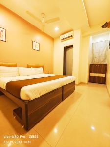 Hotel Amfahh - Andheri West Railway Station في مومباي: غرفة نوم بسرير كبير في غرفة