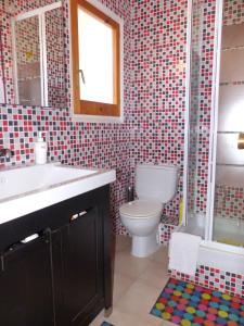 een badkamer met een toilet, een wastafel en een raam bij Beach House Roda de Bera in Roda de Bará