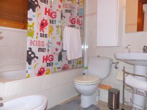 uma casa de banho com um WC, um lavatório e uma cortina de chuveiro em Beach House Roda de Bera em Roda de Bará