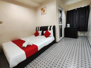 Schlafzimmer mit einem Bett mit roten und weißen Kissen in der Unterkunft Ar Rayyan Hotel in Tanah Rata