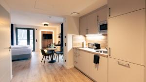 uma cozinha com um lavatório e uma mesa num quarto em Nena Apartments SPREEblau em Berlim