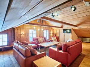 a living room with leather furniture and a wooden ceiling at Gästehaus Hof Maiezyt in Habkern +27 photos