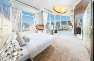 a bedroom with a large bed and large windows at Regal Hongkong Hotel in Hong Kong