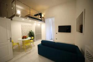 a living room with a blue couch and a table at NANNI LOFT HOUSE in Castellammare di Stabia