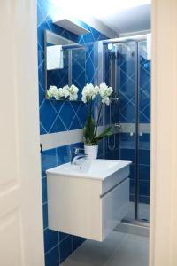 a bathroom with a white sink and blue tiles at NANNI LOFT HOUSE in Castellammare di Stabia