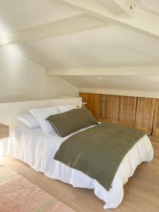 a bedroom with a bed with white sheets and pillows at Jolie villa à quelques pas du centre-ville. in Nîmes