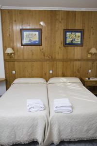 a bedroom with a bed with two towels on it at Hotel Restaurante Prado in Boal