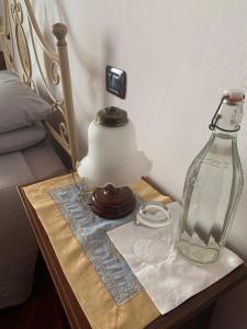 カリアリにあるB&B Federicaのランプとガラスのボトルが置かれたテーブル