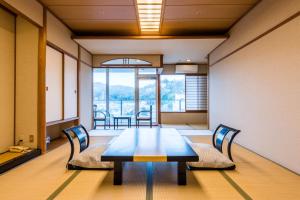 a conference room with a wooden table and chairs at Ooedo Onsen Monogatari Ito Hotel New Okabe in Ito