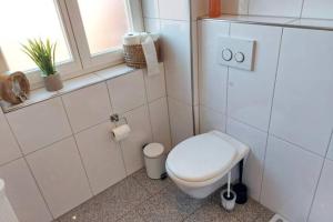 a white bathroom with a toilet and a window at Schöne Ferienwohnung im Münsterland in Dülmen