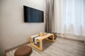 a living room with a table and a tv on a wall at 武陵山水客栈Wuling Shanshui Hotel in Zhangjiajie
