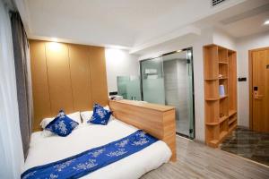 a bedroom with a large bed and a bathroom at 武陵山水客栈Wuling Shanshui Hotel in Zhangjiajie
